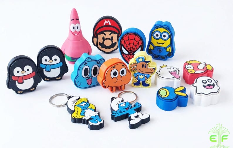May include: A collection of colorful character keychains, including a pink starfish, a penguin with a scarf, and a blue Minion. The keychains feature various cartoon and comic book characters, perfect for fans of pop culture.