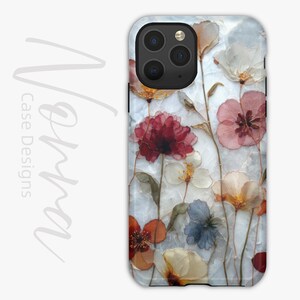 May include: A phone case featuring a floral design with pressed flowers in shades of red, pink, white, and orange. The case has a marble-like background and a camera cutout.