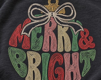 May include: A charcoal gray sweatshirt featuring an embroidered Christmas ornament design. The ornament is shaped like a circle with a bow on top and contains the text MERRY & BRIGHT in red, green, and gold thread with a spiral stitch pattern.