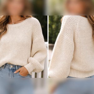 May include: Cream-colored knit sweater with a textured pattern. The sweater has a round neckline and long sleeves with ribbed cuffs. The model is wearing the sweater with blue jeans. The sweater is a cozy and comfortable garment.