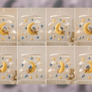 May include: A handcrafted baby mobile with a yellow crescent moon holding a sleeping teddy bear, white clouds, blue and yellow stars, and hanging blue and yellow spheres. The mobile is suspended from a white circular frame.