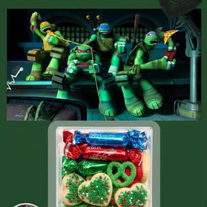 May include: Image featuring the Teenage Mutant Ninja Turtles with a Valentine's Day theme. The image includes a box of cookies and candies. The cookies are heart-shaped and decorated with green sprinkles. The candies are wrapped in red, blue, and green foil.