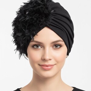 Puede incluir: Tocado negro estilo turbante con un grupo de plumas negras en el lateral. La tela parece ser un material de punto suave. El tocado est&aacute; dise&ntilde;ado para ser usado en la cabeza.