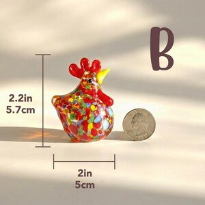May include: A colorful glass rooster figurine, 2.2 inches tall and 2 inches wide, with red, yellow, and blue accents. The figurine weighs 3 ounces. A coin is next to the rooster for size comparison. The word "B" is in the background.