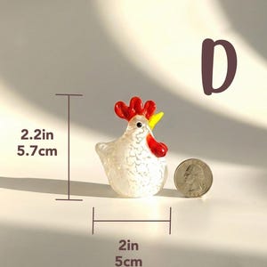 May include: A small, decorative glass rooster figurine. The white body has a speckled pattern, with red comb and wattle, and a yellow beak. The rooster is 2.2 inches (5.7 cm) tall and 2 inches (5 cm) wide. Weight: 85g.