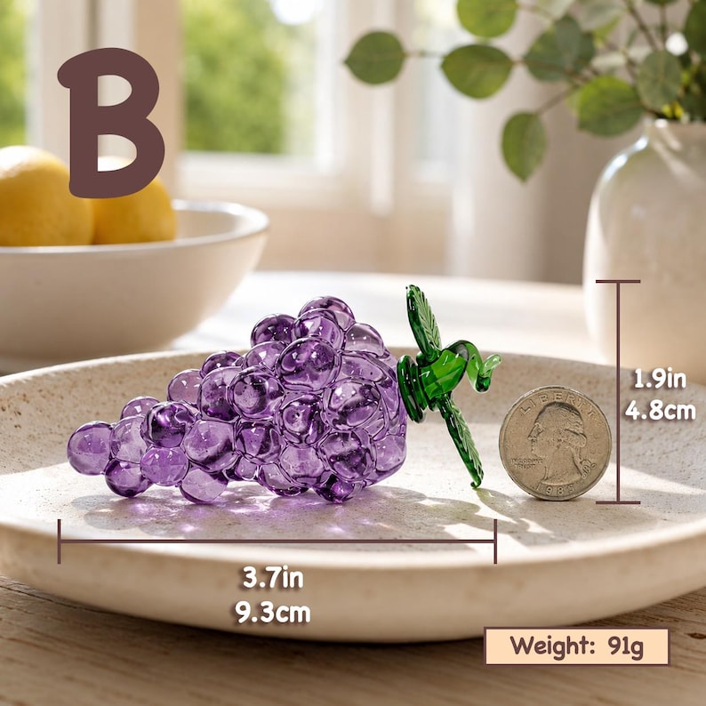 May include: A purple glass grape cluster figurine with a green glass leaf accent. The object measures 3.7 inches in length and 1.9 inches in height, with a weight of 91 grams. A US quarter coin is placed next to the glass grapes for scale.