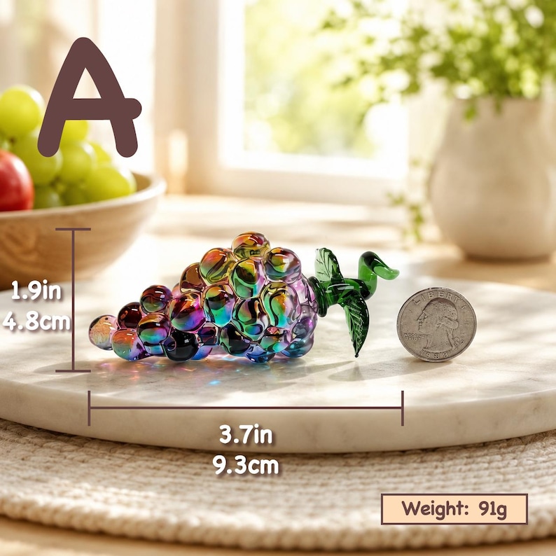 May include: An iridescent glass grape cluster figurine with a green glass leaf. The object measures 1.9 inches in height and 3.7 inches in length, with a weight of 91 grams. A US quarter coin is placed next to the glass grapes for scale.