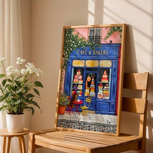 Charming Paris café art print featuring a classic blue storefront on a quaint city street, with a small dog waiting patiently beside a table of pastries. Croissants and coffee add a cozy morning feel, while soft light and European details evoke a relaxed Parisian atmosphere. Elegant yet whimsical wall art perfect for kitchens, cafés, or living spaces, celebrating travel, food, and everyday moments in France.