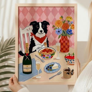 May include: A framed art print depicts a dog enjoying spaghetti. The dog wears a red bandana and sits at a table with champagne, flowers, and appetizers. A bottle of Moët champagne is visible. The background has a pink diamond pattern.