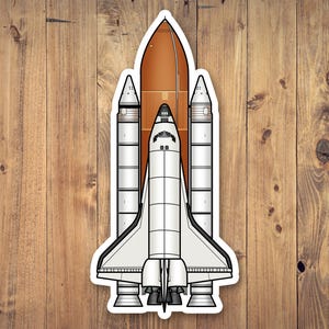 May include: A sticker featuring a detailed illustration of a space shuttle. The design includes a white shuttle with black accents, a brown fuel tank, and two white booster rockets. The sticker is outlined in white.