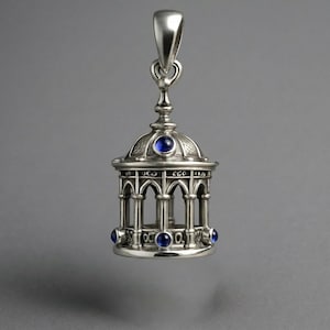 May include: Silver pendant shaped like a gazebo, with arched openings and a domed roof. It has blue gemstone accents and a loop for a chain. The pendant is a decorative item.