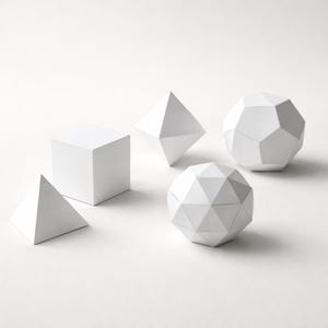 Puede incluir: Una colección de formas geométricas blancas, incluyendo un cubo, una pirámide y varios poliedros. Los objetos están dispuestos sobre una superficie blanca, creando una estética minimalista y moderna. Las formas son todas blancas y tienen bordes afilados.