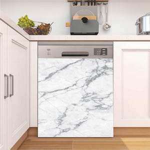 Puede incluir: Una cubierta de lavavajillas con un patrón de mármol blanco y gris instalada en una cocina moderna. La cubierta se aplica a la parte frontal de un lavavajillas de acero inoxidable. La cocina tiene gabinetes blancos y una encimera con un cuenco de uvas.