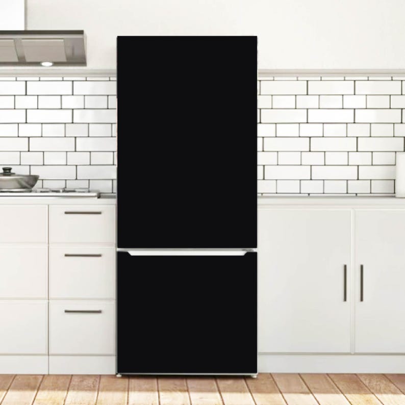 K&ouml;nnte beinhalten: Ein hoher, mattschwarzer K&uuml;hlschrank mit zweit&uuml;rigem Design, bestehend aus einem oben liegenden Hauptfach und einem unteren Gefrierfach. Das Ger&auml;t hat eine schlichte, einfarbig schwarze Oberfl&auml;che mit einem horizontalen silbernen Griff.