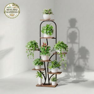May include: A multi-tiered plant stand with a black metal frame and wooden shelves. The stand holds several potted plants with green foliage and white pots. The Malibu Bamboo logo is in the upper left corner.