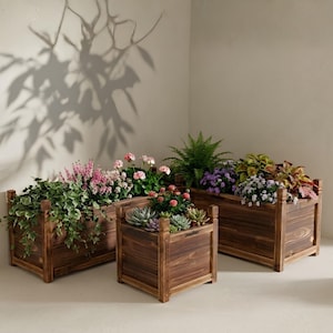 May include: Three dark brown wooden planters of varying sizes, arranged in a cluster. The planters are filled with a variety of green foliage, pink flowers, purple blossoms, and succulents, creating a lush display of plants in wooden containers.