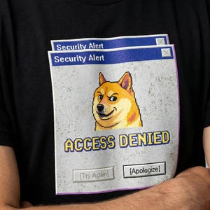 Könnte beinhalten: Schwarzes T-Shirt mit einem Pixel-Shiba-Inu-Hund und dem Text "ACCESS DENIED" in einem Computerfenster-Design. Das Design enthält den Text "Security Alert" und die Schaltflächen "Try Again" und "Apologize".