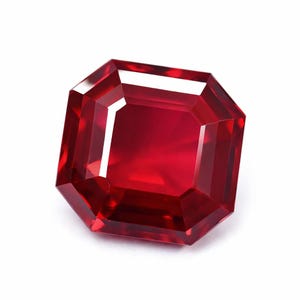 Peut inclure: Une pierre précieuse rouge vif et profonde avec une taille à facettes octogonale. La pierre présente des bords géométriques nets et une surface hautement polie et réfléchissante qui affiche une réfraction interne de la lumière.