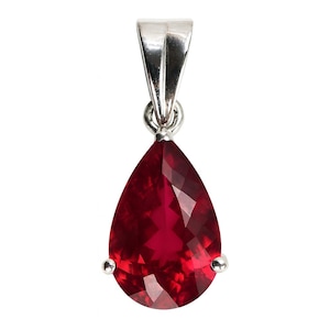 Könnte beinhalten: Ein tropfenförmiger Anhänger mit einem facettierten, tiefroten Edelstein. Der Stein ist in einer silberfarbenen Metalleinfassung mit einer Schlaufe für eine Kette gefasst. Der Anhänger ist ein Schmuckstück.