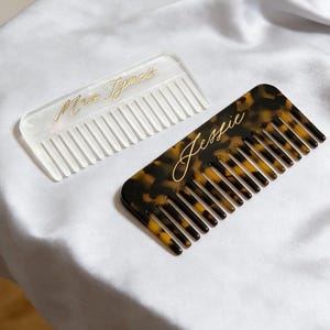 Może przedstawiać: Rustykalny drewniany szyld z napisem "Welcome to our home" w białych literach. Szyld ma postarzaną powierzchnię i prosty, zapraszający design, idealny do dekoracji wejścia.