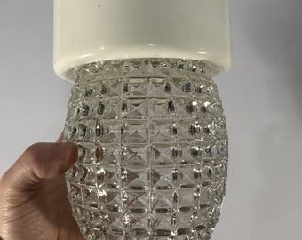May include: A clear glass ceiling light fixture with a white plastic top. The glass is textured with a diamond pattern.