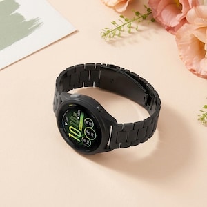 May include: A black smartwatch with a matching black metal link band. The circular watch face displays a digital interface with green accents, showing the time as 10:10, a heart rate icon, and various activity tracking metrics on a dark background.