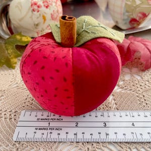 Red patchwork fabric apple shown with ruler for size reference.