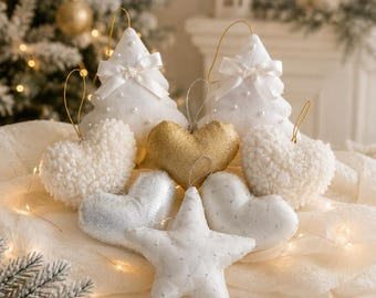May include: A collection of fabric ornaments including two white Christmas trees with satin bows, two white textured heart ornaments, one gold heart, one silver heart, one white heart with silver dots, and one white star with silver dots.