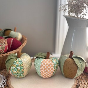 Three handmade green patchwork fabric apples in coordinating green, cream and golden cotton prints.