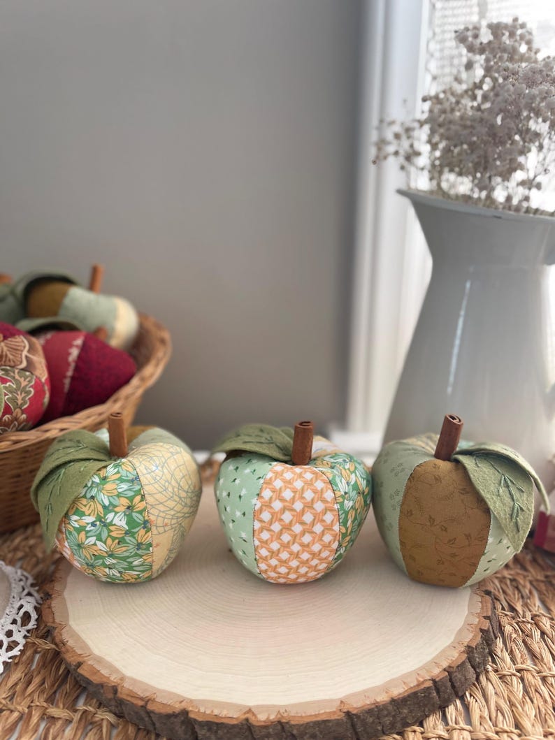 Three handmade green patchwork fabric apples in coordinating green, cream and golden cotton prints.