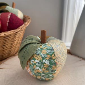 Single green patchwork fabric apple made from coordinating green, cream and golden cotton fabrics.
