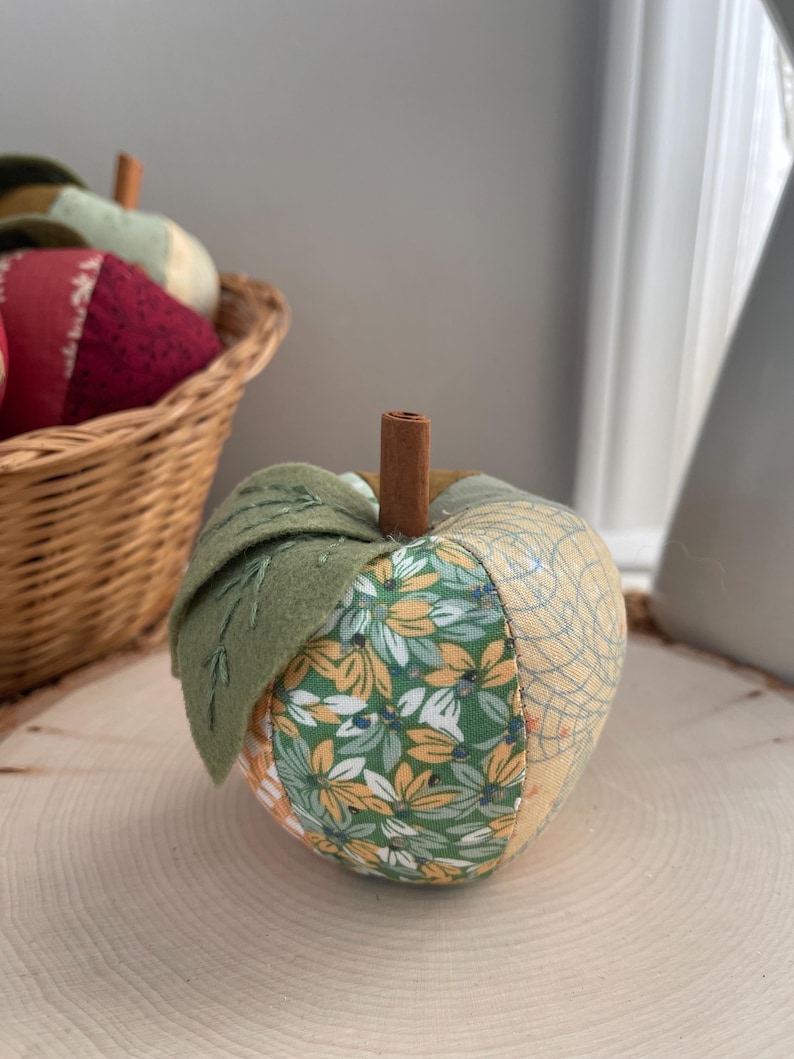 Single green patchwork fabric apple made from coordinating green, cream and golden cotton fabrics.