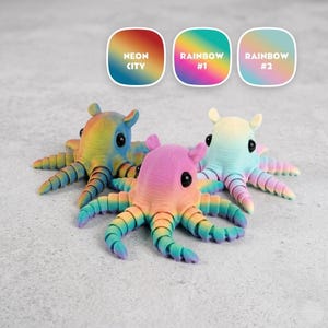 May include: Three colorful octopus figurines in rainbow hues. Each octopus has a unique color gradient, with tentacles and bodies in shades of blue, pink, yellow, and green. The image includes three labels: "Neon City," "Rainbow #1," and "Rainbow #2."