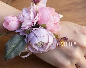 Conjunto de boutonniere de muñeca con follaje verde y color púrpura rosado para novia, novio, dama de honor y padres.