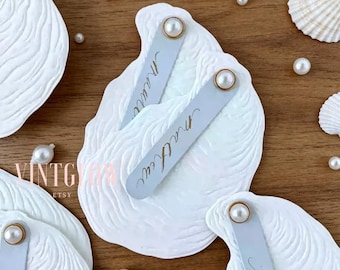 Convite de casamento personalizado com relevo de concha de ostra, estilo francês costeiro, para casamento na praia.