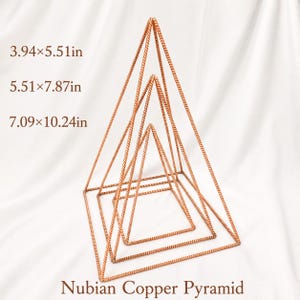 Puede incluir: Tres pirámides nubias de cobre anidadas hechas de alambre de metal trenzado. Las dimensiones indicadas son 10x14cm, 14x20cm y 18x26cm. Las estructuras son de marco abierto, geométricas, de color cobre y dispuestas en formación escalonada.