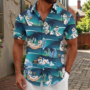 May include: A short-sleeved button-down shirt featuring a repeating tropical pattern of the character Olaf from Frozen. The design includes Olaf relaxing in hammocks, wearing sunglasses, and holding coconuts against a teal and blue background.