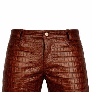 May include: Brown leather shorts with a crocodile skin texture. The shorts have a button closure and belt loops. The garment is a medium brown color and appears to be made of high-quality leather.