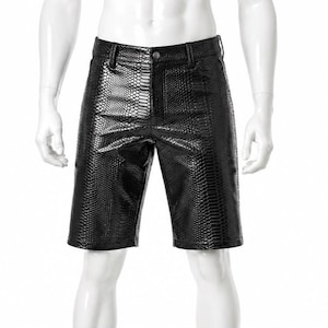 May include: Black shorts featuring a glossy, textured snakeskin pattern. These shorts include a standard waistband with a single button closure, a front zip fly, and belt loops, constructed with a structured fit that reaches above the knee.