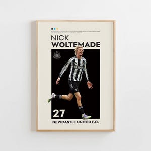Puede incluir: Póster enmarcado con el futbolista Nick Woltemade con una camiseta a rayas blancas y negras. El póster incluye el número 27, el logotipo del Newcastle United F.C. y el nombre del equipo. El fondo es de color beige claro.