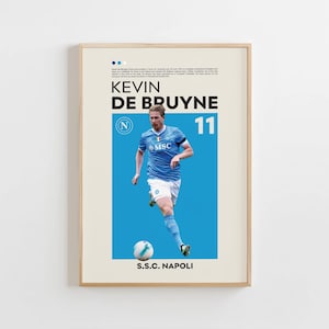 Puede incluir: Un póster enmarcado con el futbolista Kevin De Bruyne con una camiseta azul claro con el número 11. El póster tiene un fondo beige claro con texto en la parte superior y las palabras "S.S.C. NAPOLI" en la parte inferior.