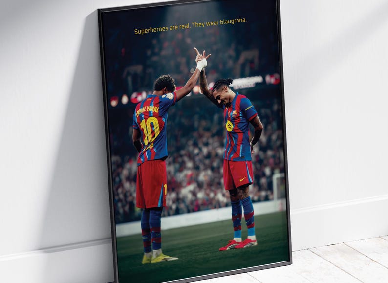 May include: Framed poster featuring two soccer players in blue and red uniforms, high-fiving on a green field. The jerseys have the number 10 on the back. Text at the top reads, "Superheroes are real. They wear blaugrana."