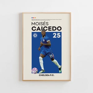 May include: A framed poster featuring Moisés Caicedo in a Chelsea F.C. uniform. The poster has a blue and white color scheme, with the player's name and number 25 prominently displayed. A soccer ball is at the bottom.