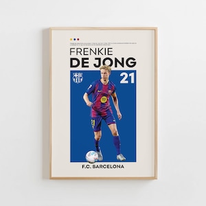 May include: A framed poster featuring soccer player Frenkie De Jong in a Barcelona uniform. The poster has a blue background with the player's name and number 21 in large text. The F.C. Barcelona logo is also visible.