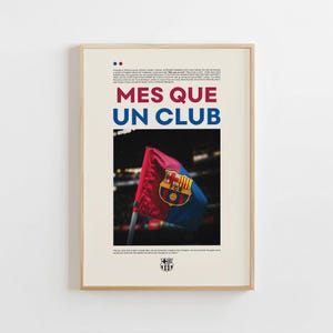 Puede incluir: Póster enmarcado con las palabras "MES QUE UN CLUB" en rojo y azul. Presenta una bandera con el escudo del FC Barcelona. El fondo es beige y el marco de madera. El texto superior está en inglés.