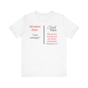 The image is a white t-shirt with text and a Bible verse printed on it.