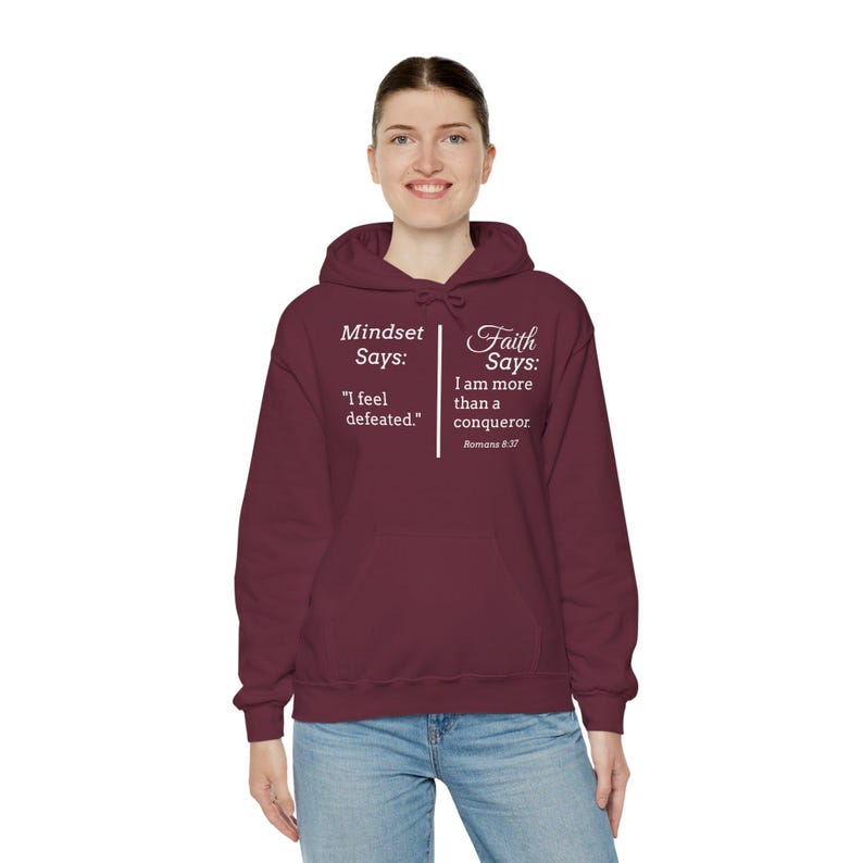 A woman wearing a maroon hoodie with text on it.