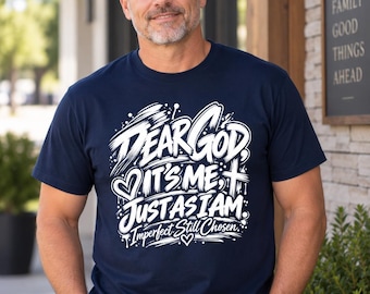 Op de afbeelding: Een marineblauw t-shirt met korte mouwen en witte grafische tekst: Dear God, It's Me, Just As I Am: Imperfect Still Chosen. Het ontwerp bevat een hartpictogram, een kruissymbool en belettering in penseelstreekstijl met verfspatten.