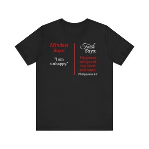 The image is a black t-shirt with text and a Bible verse from Philippians 4:7 printed on it.