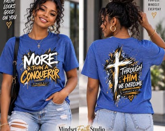 Op de afbeelding: Een koningsblauw T-shirt met korte mouwen en een grafische print. De voorkant toont de tekst "MORE THAN A CONQUEROR" met "ROMANS 8:37" eronder. De achterkant heeft een kruisafbeelding met de tekst "THROUGH HIM WE OVERCOME" en "ROMANS 8:37".